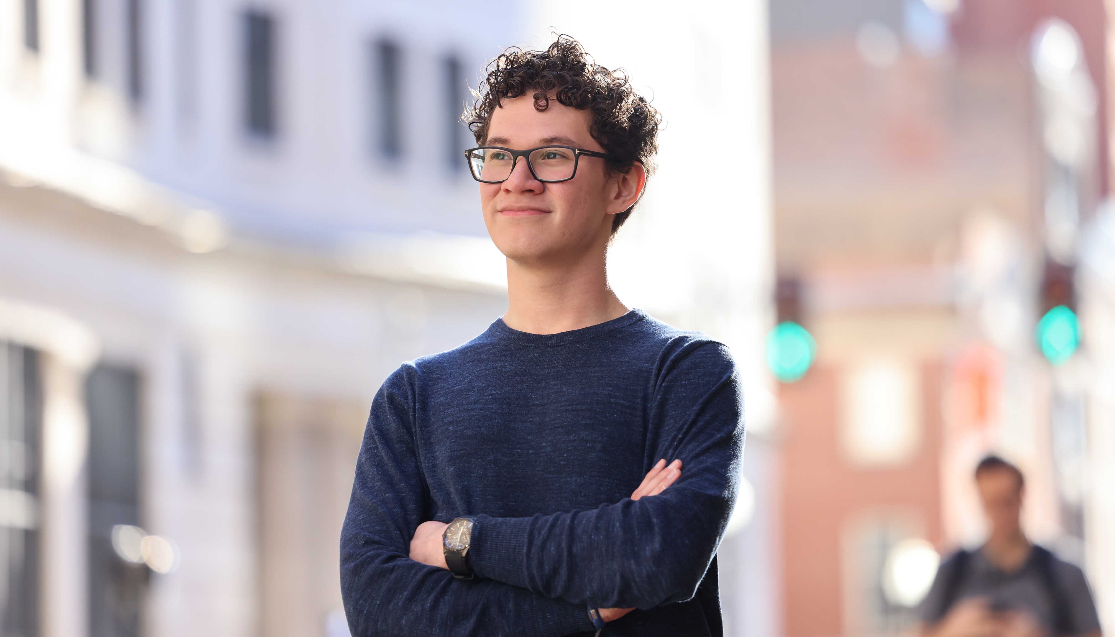 David Rivera stands outside Suffolk on Tremont Street with arms crossed
