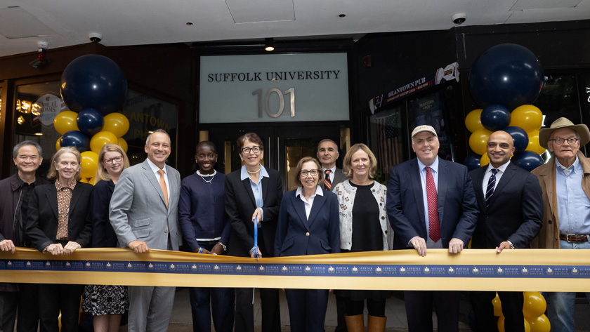 President Marisa Kelly stands in the center of a group of University and city leaders about to cut the ceremonial ribbon in front of 101 Tremont Street