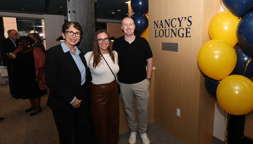 President Kelly stands with Lindsay Mistretta and Greg Stoll in Nancy's Lounge