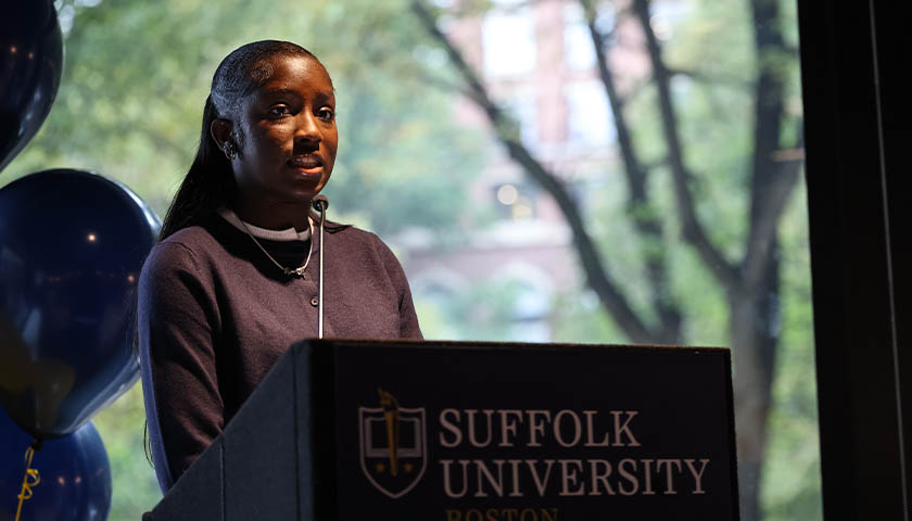 Student speaks at a Suffolk University podium in the 101 Tremont student lounge
