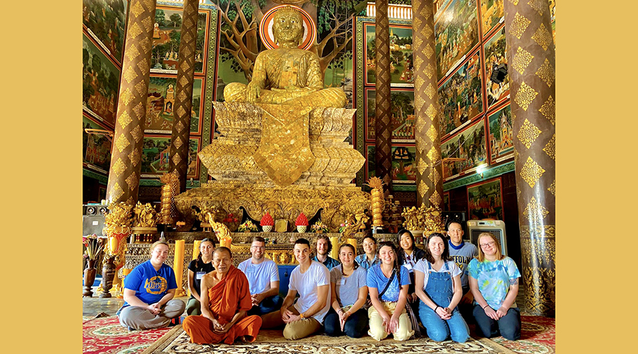 Suffolk group in front of enormous golden Buddha statue
