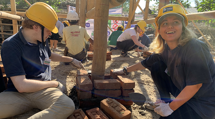 Two students laying bricks