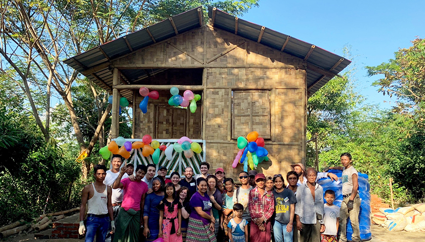 Villagers and students in front of completed bamboo house