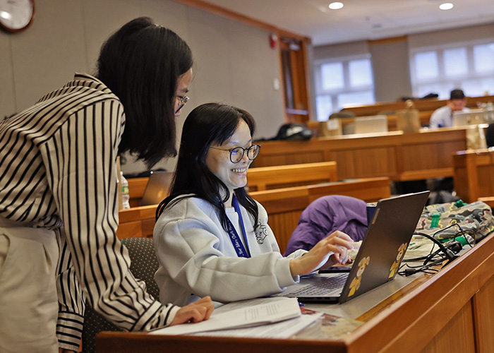 Two Suffolk students looking at a computer screen at a data analytics competition.