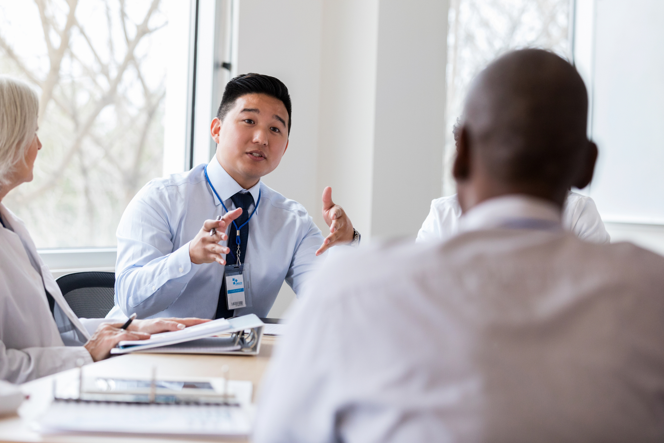 A man leading a conversation in a meeting seated at a table