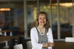 Assistant Director of Management and Administration Programs Anna Quadri smiling in white jacket