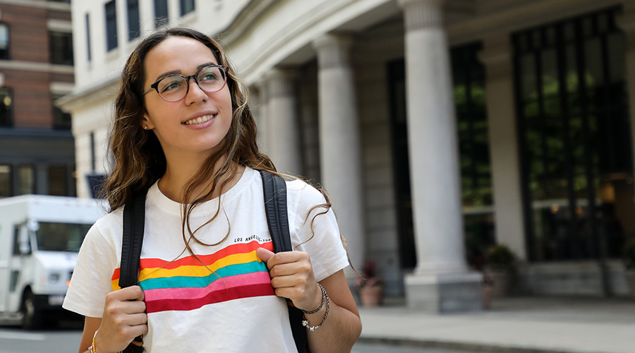 Suffolk Student Gabriela Soto walks across Tremont street with her backpack