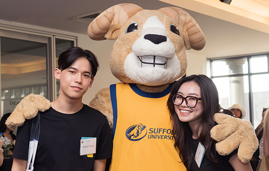 Two Suffolk students pose with Rammy, Suffolk's School mascot, at the International Students Reception.