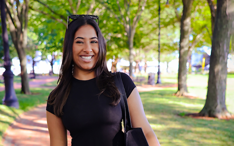 A Suffolk student poses confidently in the North End of Boston at sunset.