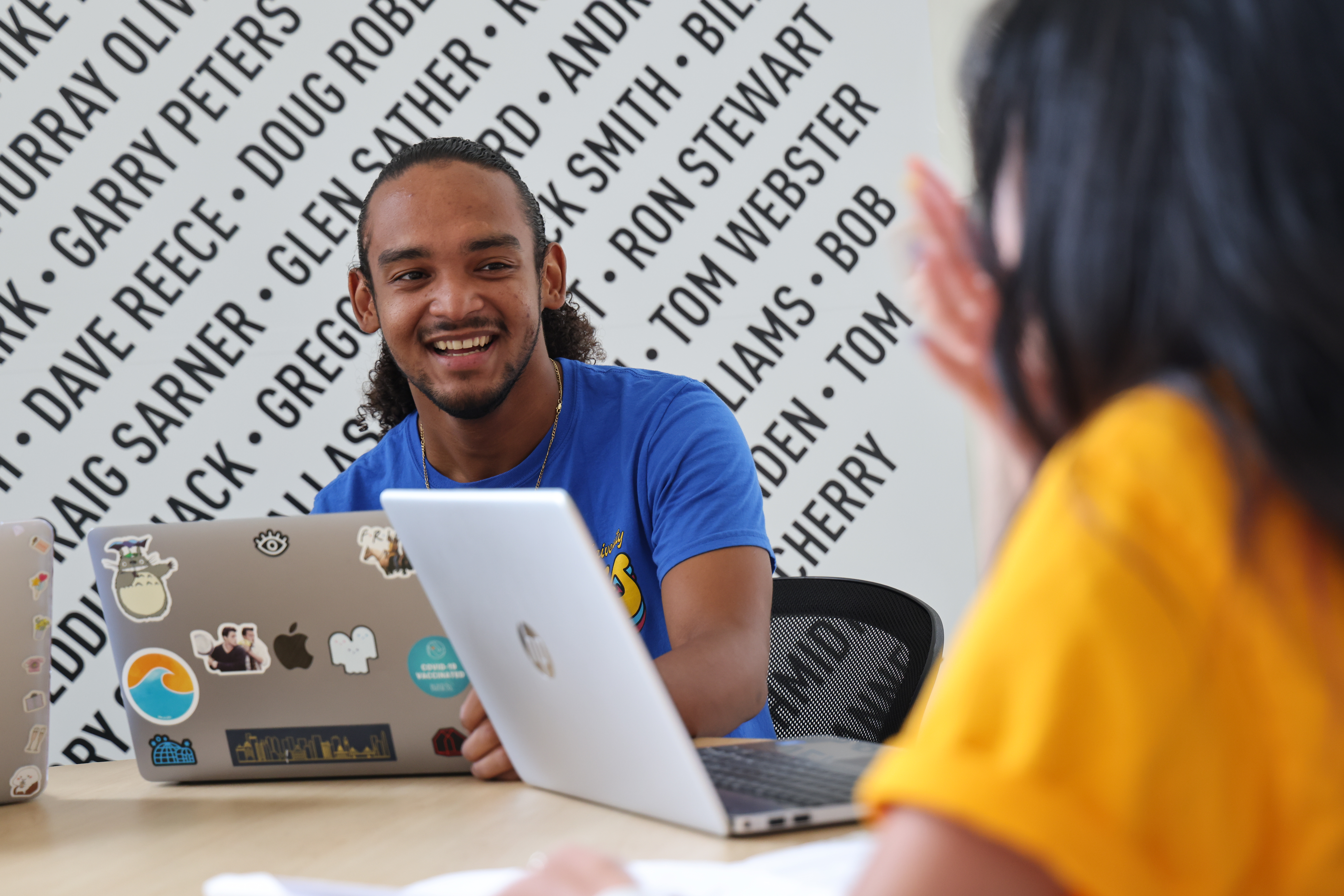 Two students sit at a table and work collaboratively together