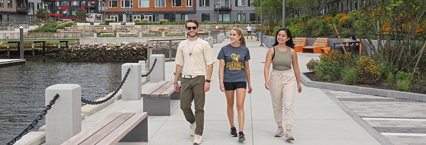 Three Suffolk students walking together in East Boston along the waterfront.
