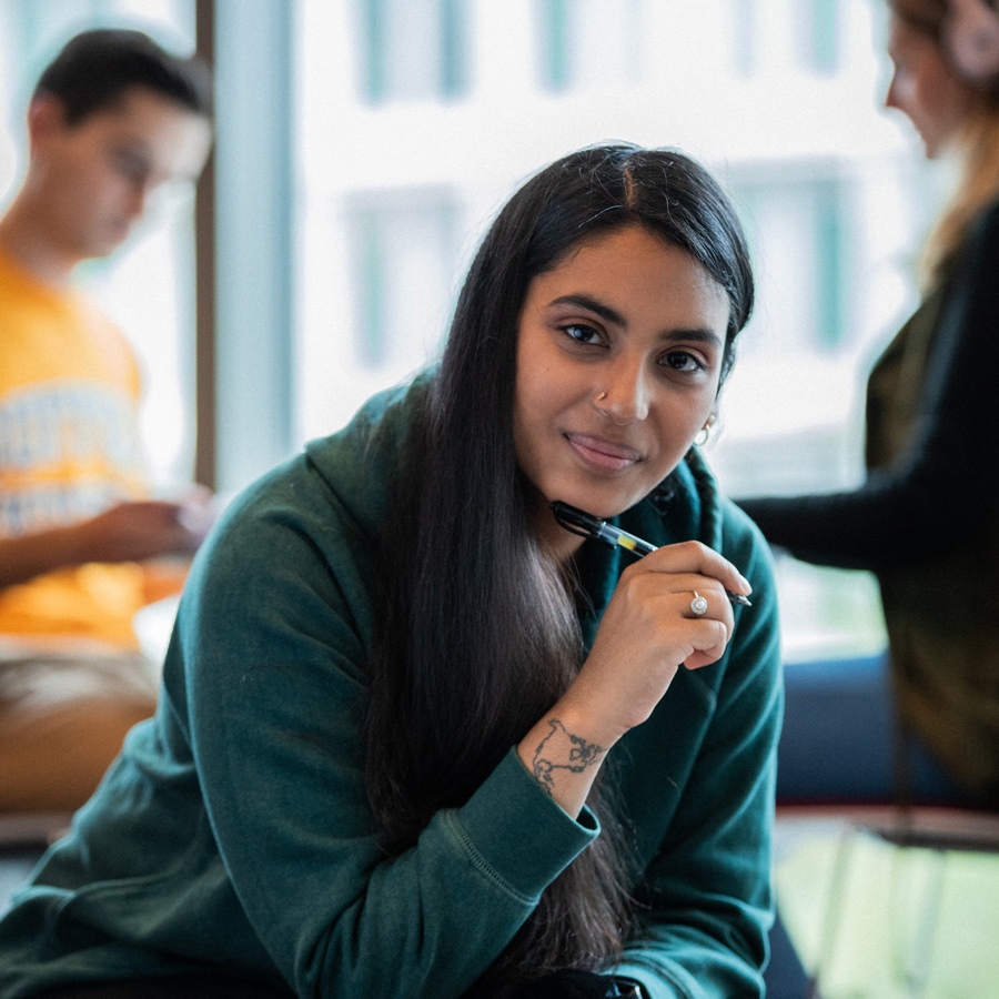 Suffolk student poses for a portrait while studying in the Samia Academic Center.